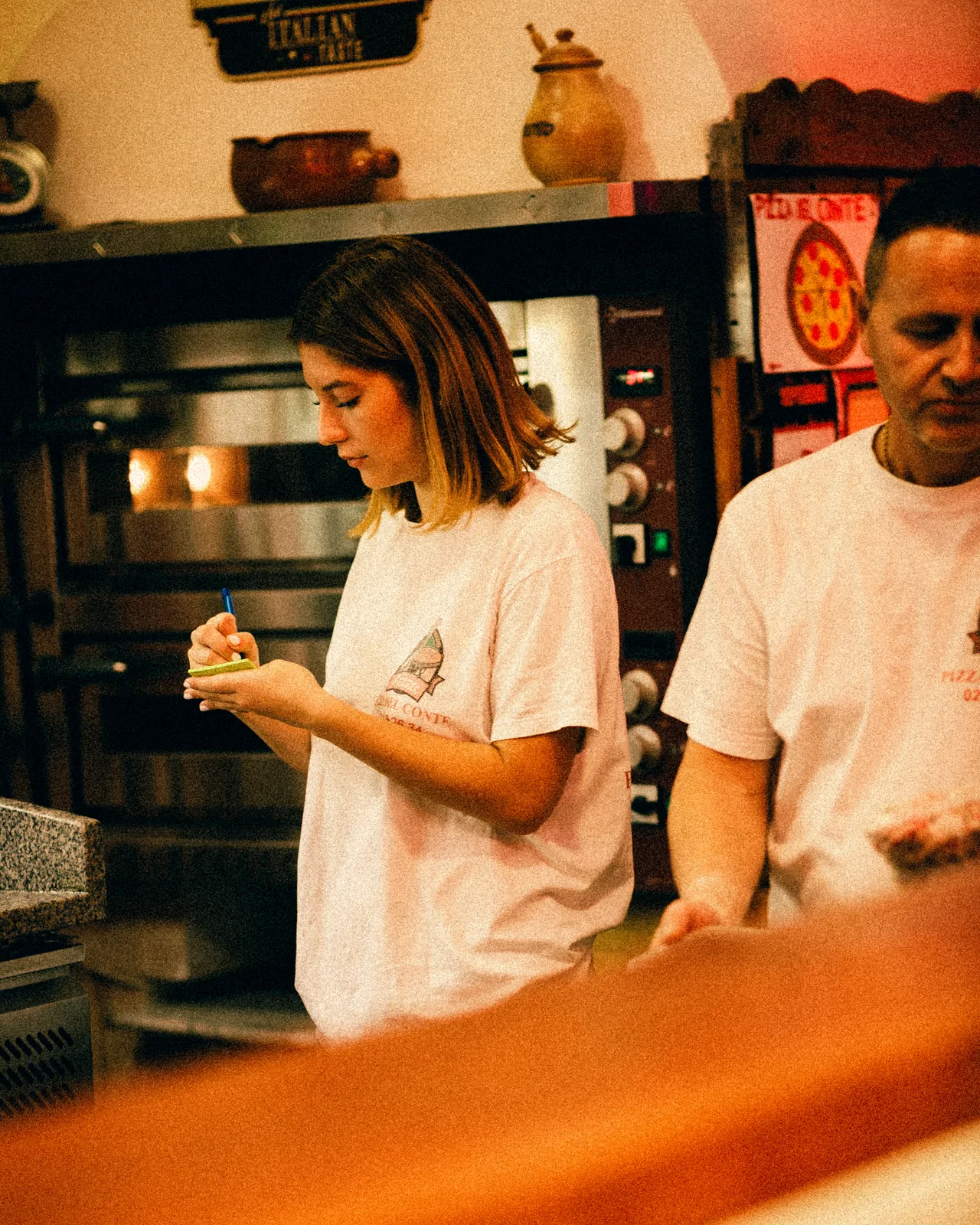 La serveuse note une commande devant le four